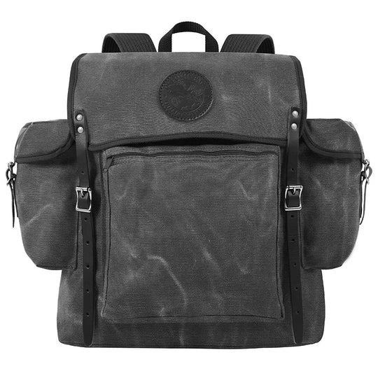 Rambler backpack in waxed grey canvas with leather straps, featuring multiple pockets for outdoor and hiking use by Duluth Pack.