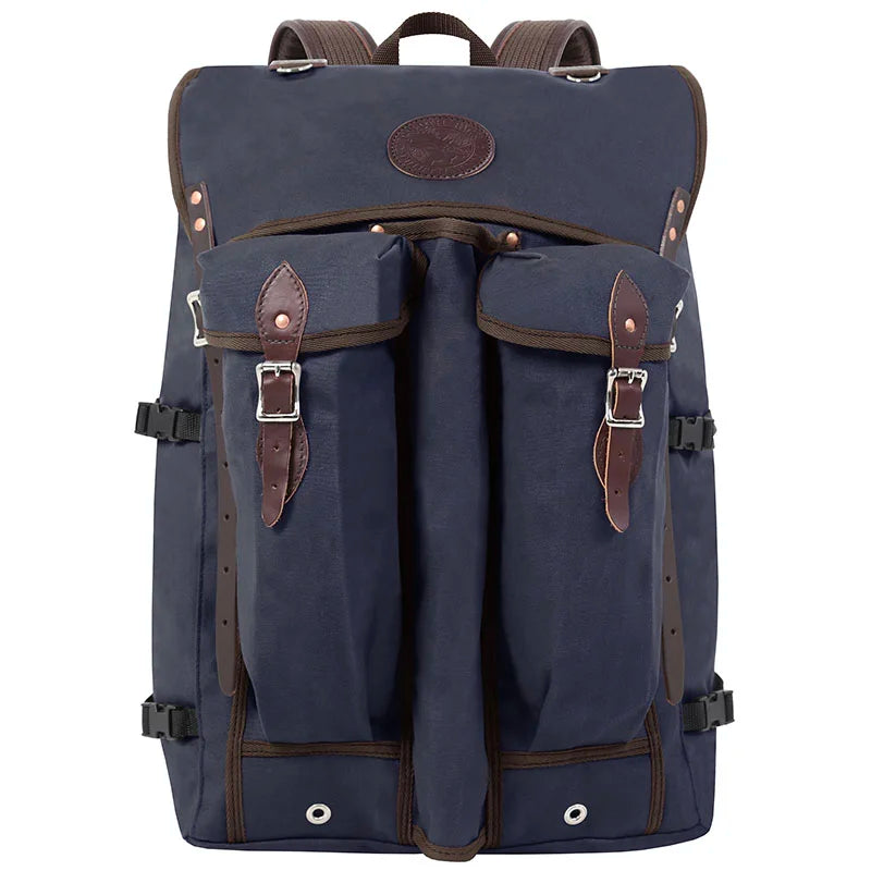 Bushcrafter backpack in navy rugged canvas with leather accents and buckle pockets, designed for durable outdoor use by Duluth Pack.