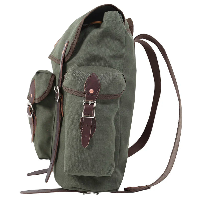Wanderer backpack in Olive Drab featuring rugged canvas and hand-cut leather reinforcements, designed for outdoor adventures and durable use.