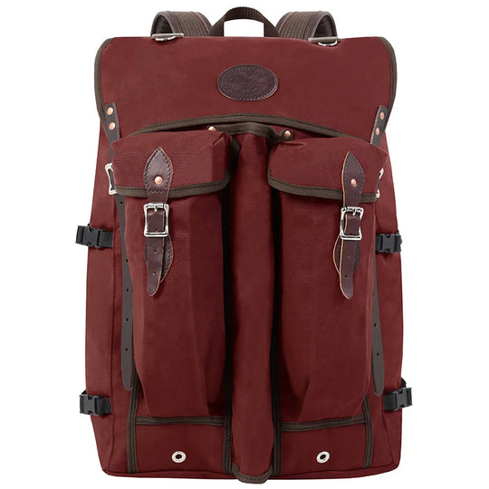 Bushcrafter backpack in rugged maroon canvas with leather accents, designed for durable outdoor use by Duluth Pack wilderness enthusiasts.