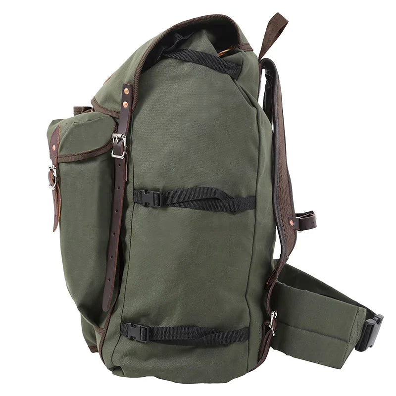 Bushcrafter backpack in rugged olive green canvas with leather accents, designed by Duluth Pack for durable outdoor use and bushcraft adventures.