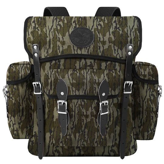 Wanderer backpack in Mossy Oak Bottomland Camo with rugged canvas and leather straps, designed for durable outdoor adventure by Duluth Pack.