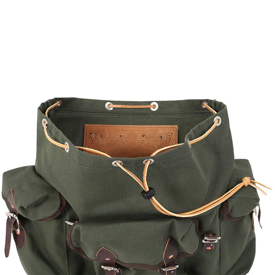 Wanderer backpack in Olive Drab with rugged canvas and leather reinforcements designed for durable outdoor use by Duluth Pack.