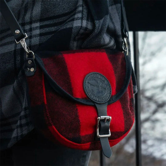 Classic Wool Small Shell Purse in red and black wool with leather strap and buckle, styled for outdoor use with durable craftsmanship heritage and rugged appeal.