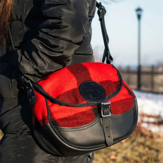 Deluxe Medium Classic Wool Shell Purse with timeless red and black wool exterior and premium leather accents, worn outdoors on a winter day.