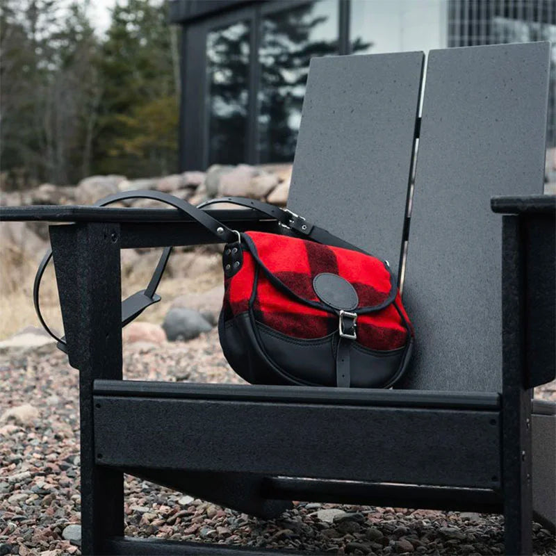 Deluxe Medium Classic Wool Shell Purse in timeless red and black wool with leather accents, resting on a rustic outdoor chair in a natural setting.