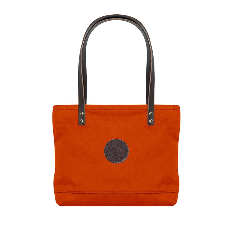 Lakewalk Tote in orange with riveted leather handles and rugged canvas, showcasing durable outdoor craftsmanship by Duluth Pack for versatile day to night use.