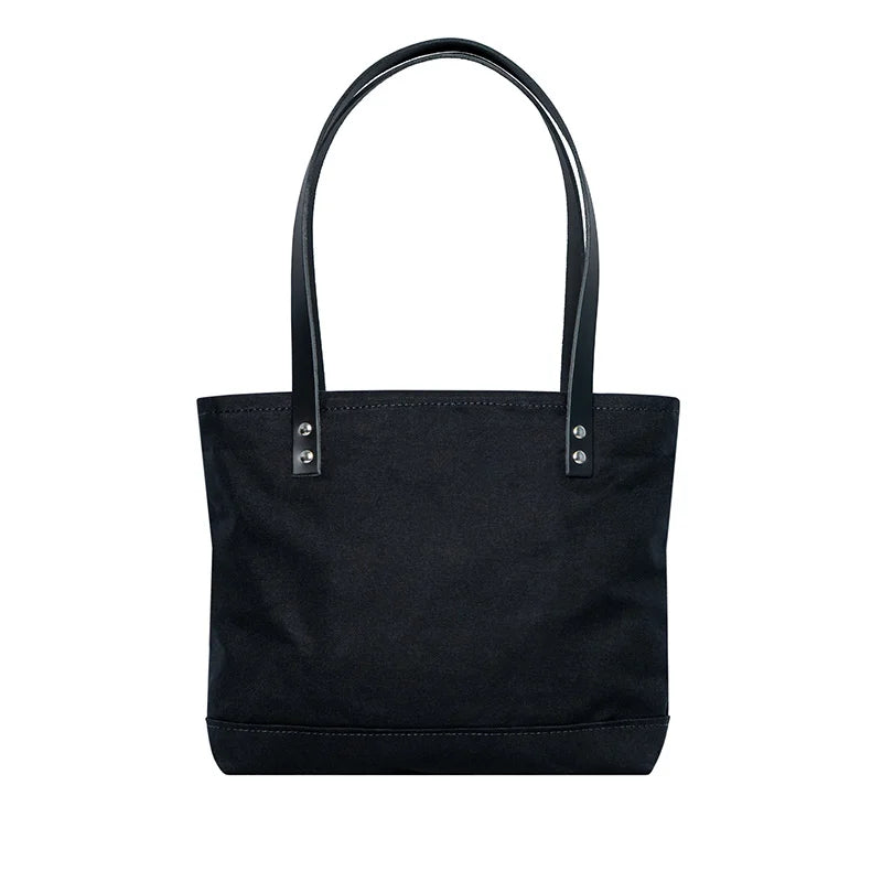 Superior Series Canvas Lakewalk Tote in black canvas with leather handles, designed by Duluth Pack for rugged outdoor use and durable everyday carry.