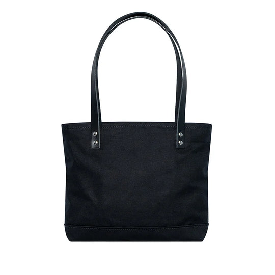 Superior Series Canvas Lakewalk Tote in black canvas with leather handles, designed by Duluth Pack for rugged outdoor use and durable everyday carry.