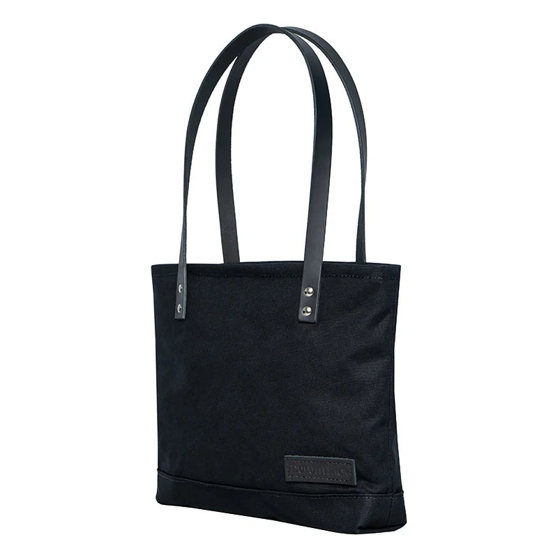 Superior Series Canvas Lakewalk Tote in black canvas with leather handles by Duluth Pack, crafted for durable outdoor use and timeless style.