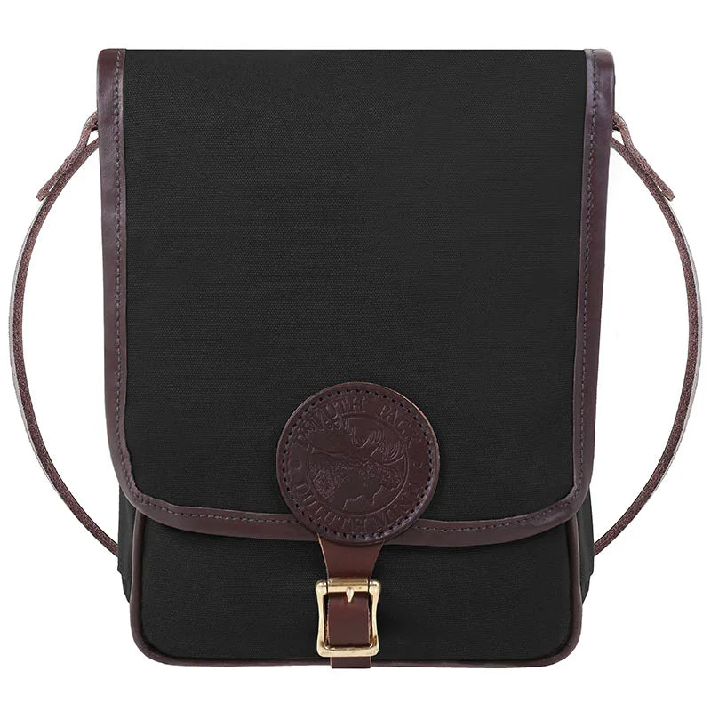 Haversack in rugged black 15-ounce canvas with premium leather trims and antique brass hardware, designed by Duluth Pack for durable outdoor use and classic style.