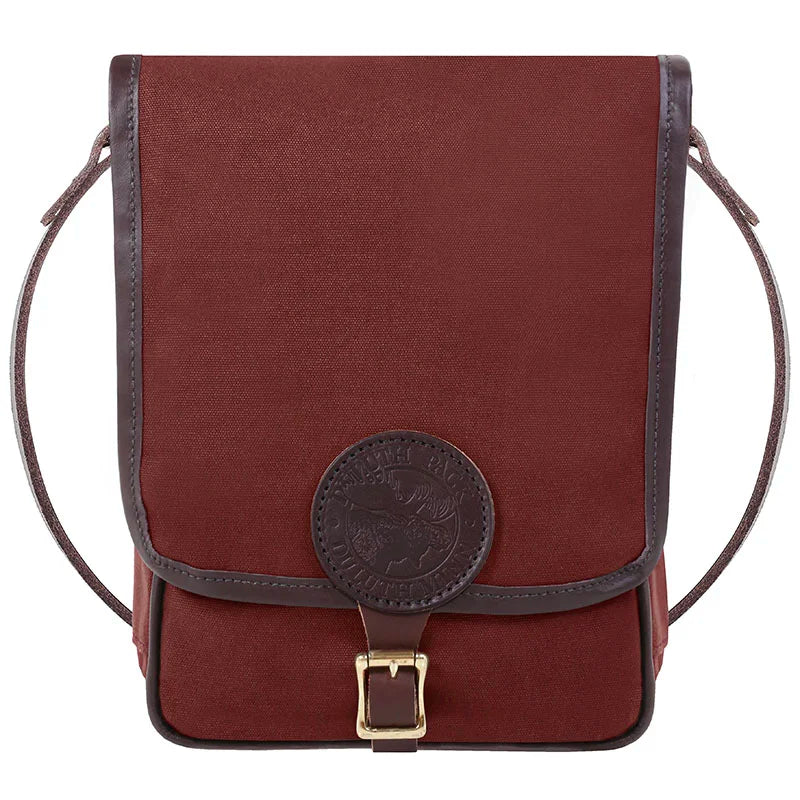 Haversack in rich brown rugged canvas with premium leather trim and antique brass buckle, designed by Duluth Pack for durable outdoor use.