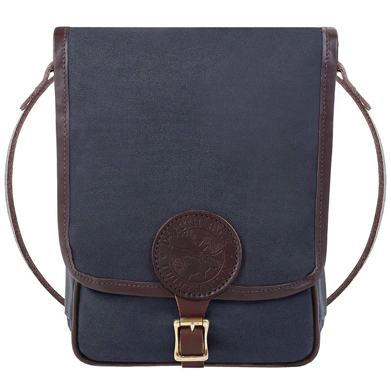 Haversack in rugged navy 15-ounce canvas with premium leather trim and brass hardware, designed by Duluth Pack for durable outdoor use and heritage craftsmanship.