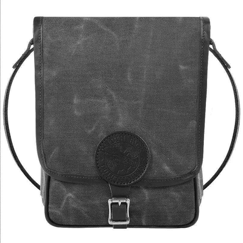 Haversack in rugged waxed gray canvas with premium leather accents and antique brass hardware, designed for durable outdoor use by Duluth Pack.
