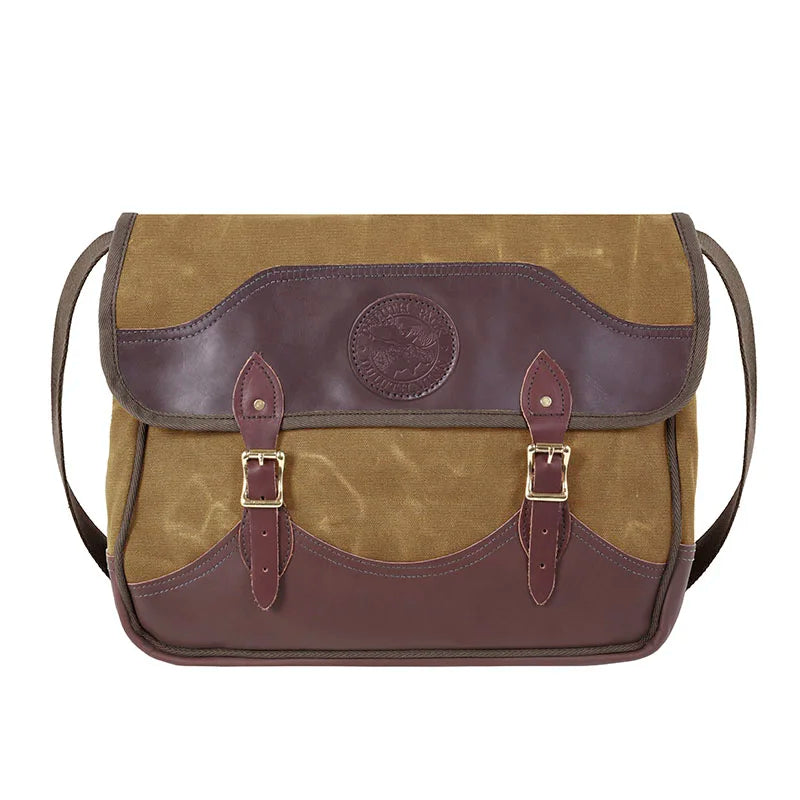 Deluxe Book Bag in waxed khaki canvas with handcrafted leather trim and brass hardware, showcasing durable outdoor craftsmanship from Duluth Pack.