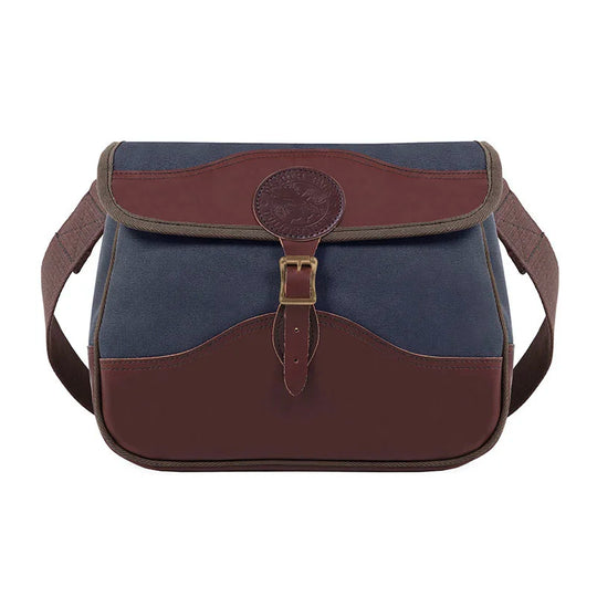 Field Satchel in navy rugged 15-ounce canvas with thick premium leather trim and antique brass hardware, designed for durable outdoor use by Duluth Pack.