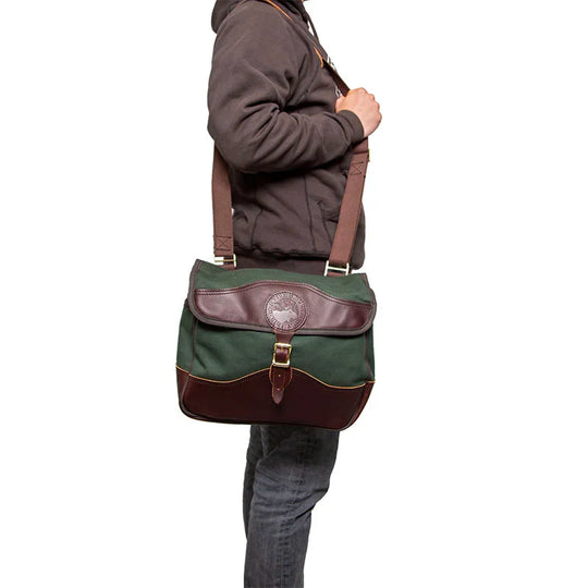 Field Satchel in green rugged 15-ounce canvas with premium leather accents worn over the shoulder, highlighting durable handmade outdoor craftsmanship.