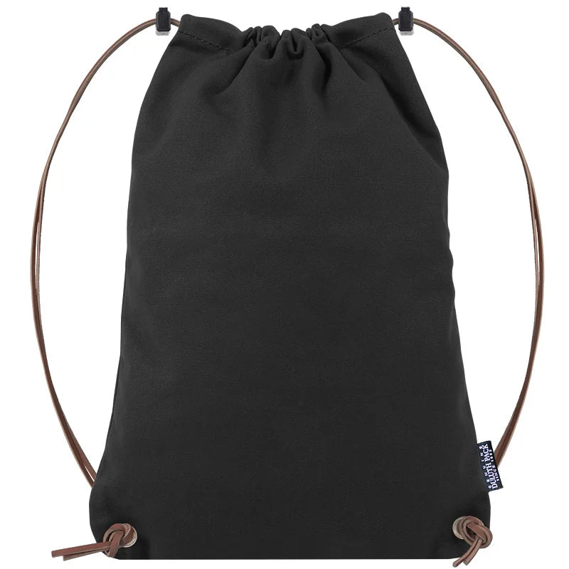 Drawstring Backpack in black canvas with premium adjustable leather drawstrings by Duluth Pack, designed for durable outdoor use and comfortable carrying.