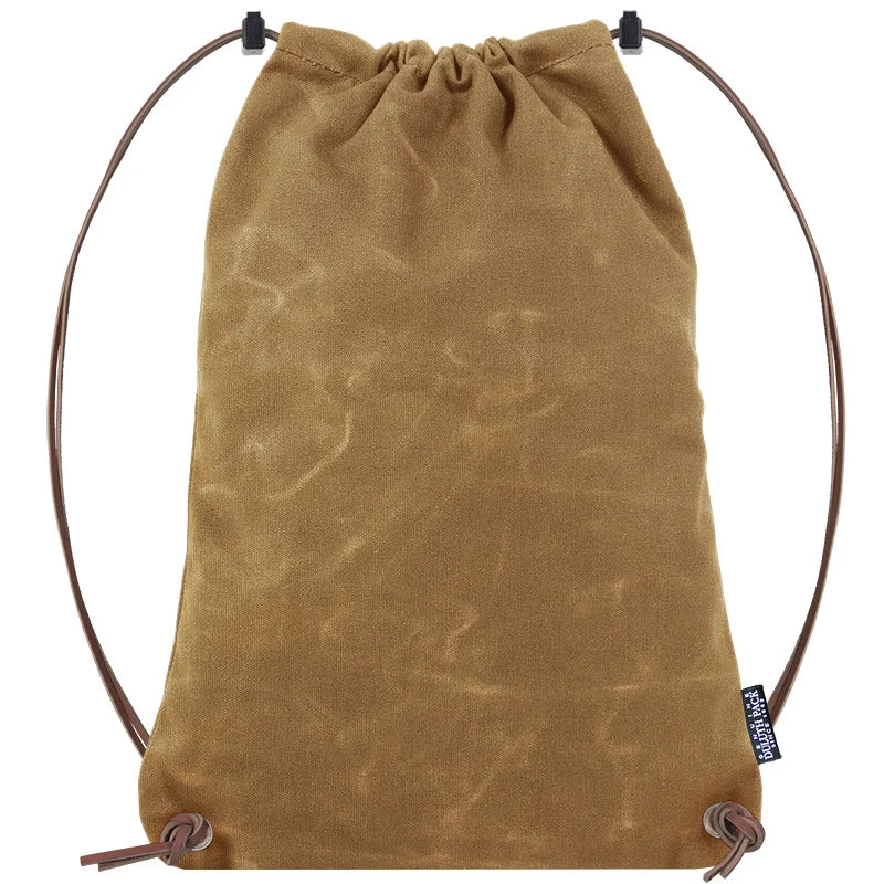 Drawstring Backpack in rugged waxed canvas with premium adjustable leather drawstrings by Duluth Pack, designed for durable outdoor use and everyday carry.