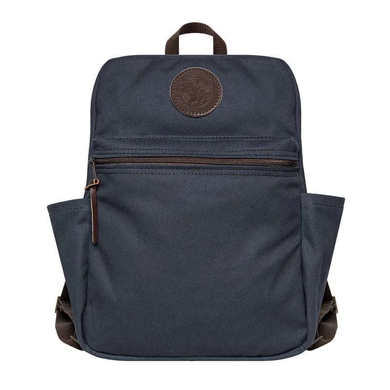 NEW Standard Backpack in navy with leather accents, featuring durable handmade canvas and side pockets, designed for rugged outdoor use and everyday durability.