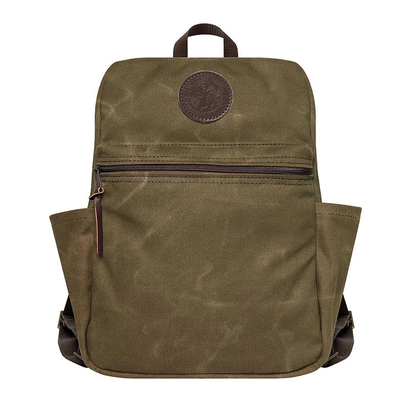 NEW Standard Backpack in waxed khaki canvas with side pockets and leather zipper pull, designed for durable everyday outdoor use by Duluth Pack heritage craftspeople.