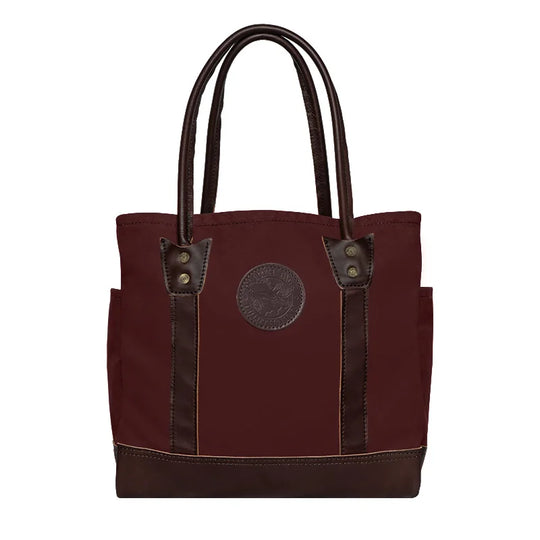 Highlander Tote in burgundy with leather accents featuring durable canvas construction, designed by Duluth Pack for versatile everyday use and rugged outdoor settings.