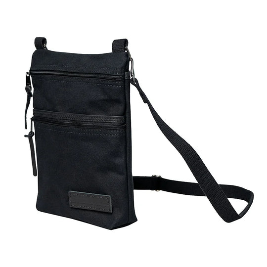 Superior Series Canvas Traverse Crossbody in black canvas with two zippered compartments and adjustable cotton web shoulder strap, ideal for everyday travel and outdoor use.