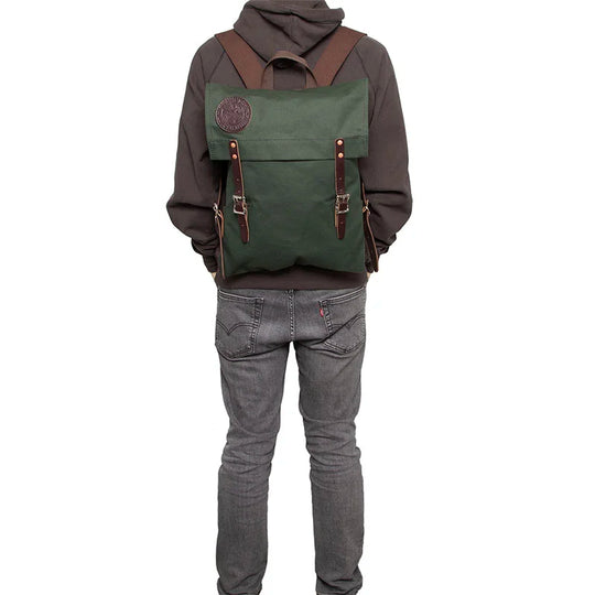 Scout Pack in Olive Drab featuring durable canvas and leather straps, worn by person in casual outdoor attire, showcasing heritage craftsmanship and rugged design