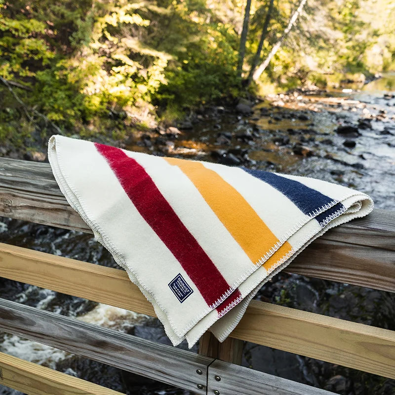 Faribault Frontier Blanket in Bone with a creek in the background