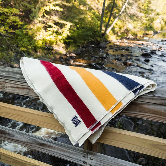 Faribault Frontier Blanket in Bone with a creek in the background