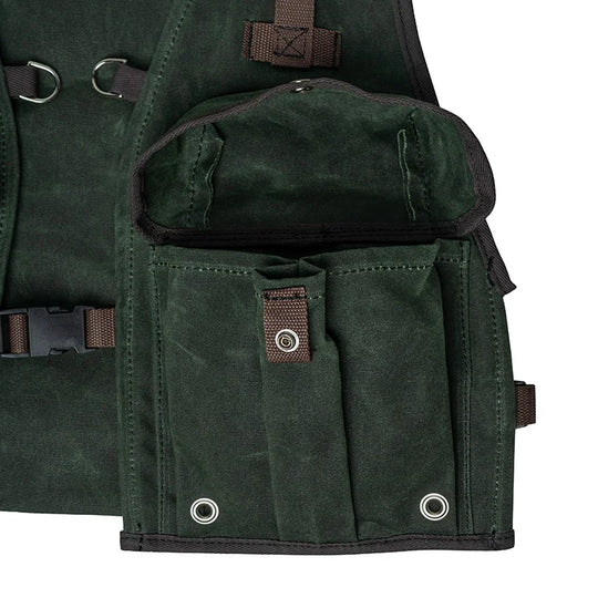 Fly Vest in dark green canvas with multiple exterior pockets and back mounted d-ring, designed for durable and accessible fly fishing gear use by Duluth Pack.