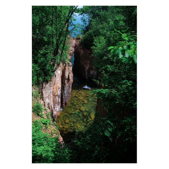 Postcard photo by Gavin Weiers of man in inner-tube on North Shore of Minnesota near cliffs