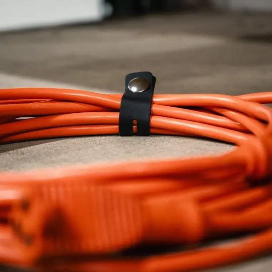 Leather Cord Organizer Being Used On An Orange Extension Cord