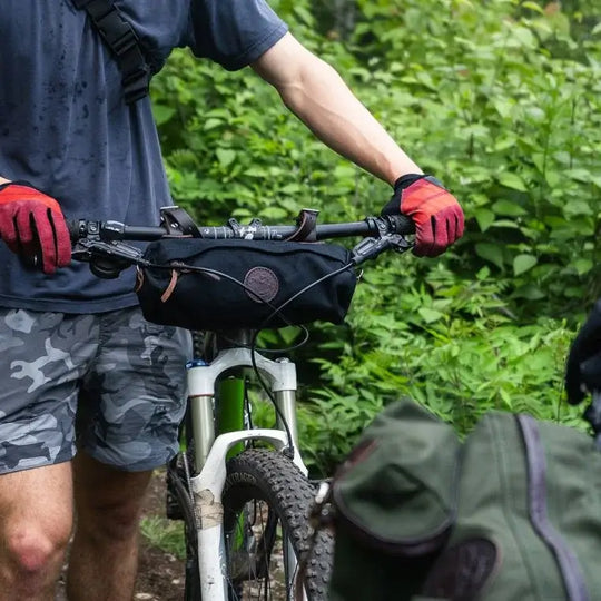 Candy Bar Bike Bag In Black Installed On The Handle Bars Of A Mountain Bike Being Used By A Man