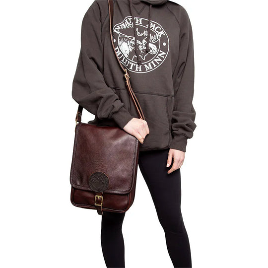 Leather Haversack in rich pebbled leather worn crossbody by a person dressed for outdoor rugged use, highlighting durable craftsmanship and classic style.