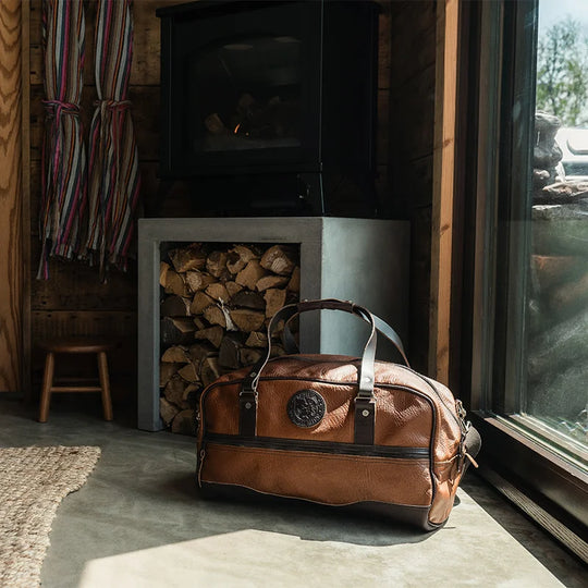 Duluth Pack Bison Leather Weekender Duffel in black in a cabin