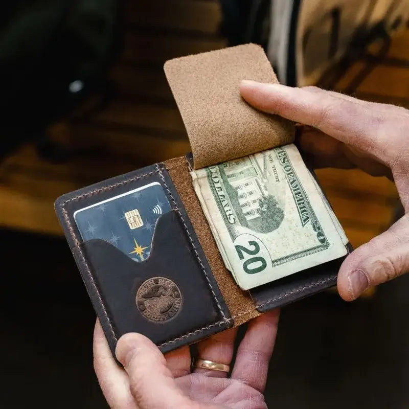 Duluth Pack Money Clip Wallet in brown open with someone holding it