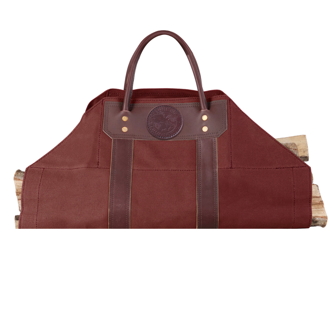 Log Carrier in rich brown canvas with leather reinforcements, designed for carrying firewood easily at home, cabin, or camping settings.
