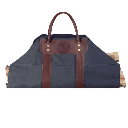 Log Carrier crafted from navy canvas with riveted leather trim and handles, designed for carrying firewood at home, cabin, or camping.