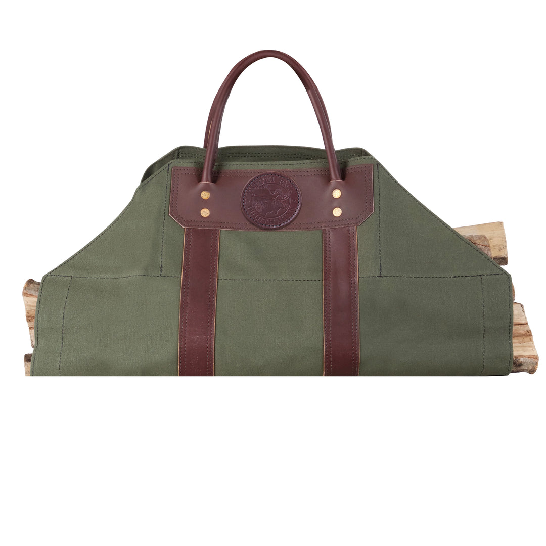 Log Carrier in olive green canvas with riveted leather reinforcements, designed for carrying firewood at home, cabin, or camping settings.