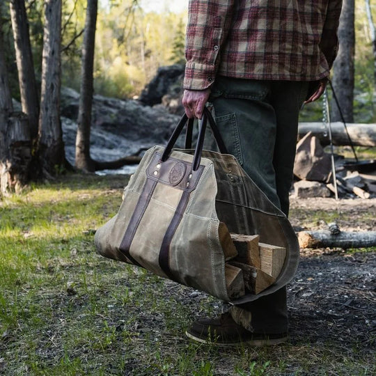 DOODLE BAG CHARM (PDP Test) rugged canvas and leather tote bag carrying firewood outdoors, showcasing durable craftsmanship by DOUGLAS COMPANY, INC.