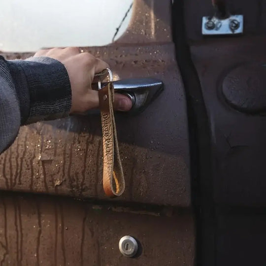 Duluth Pack Leather Keychain in bison with an old car in the background