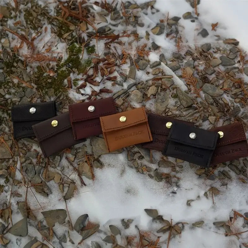 Duluth Pack Leather Hold-All Snap Wallet in assorted leather colors with snowy background. 