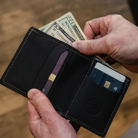 Duluth Pack Leather Bifold Wallet in brown open with wood background