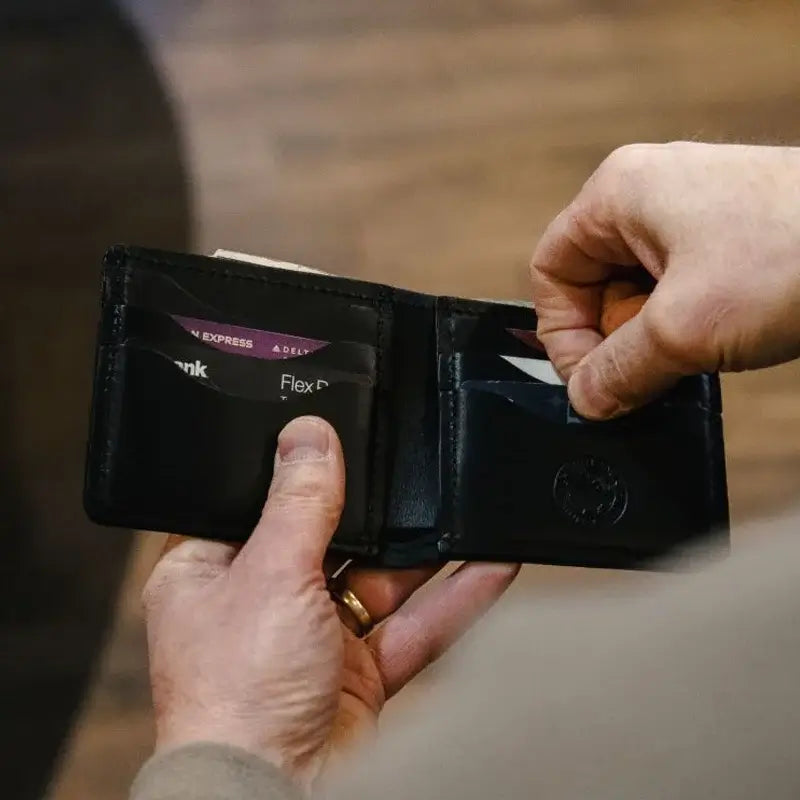 Duluth Pack Credit Card Bifold Wallet in black with someone holding the wallet
