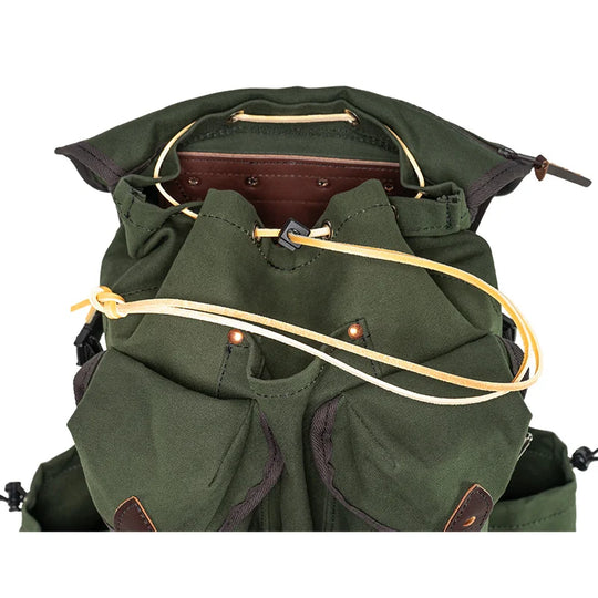 Outlander Pack in dark green canvas with leather accents and drawcord closure, designed for rugged outdoor use and tight trail navigation.