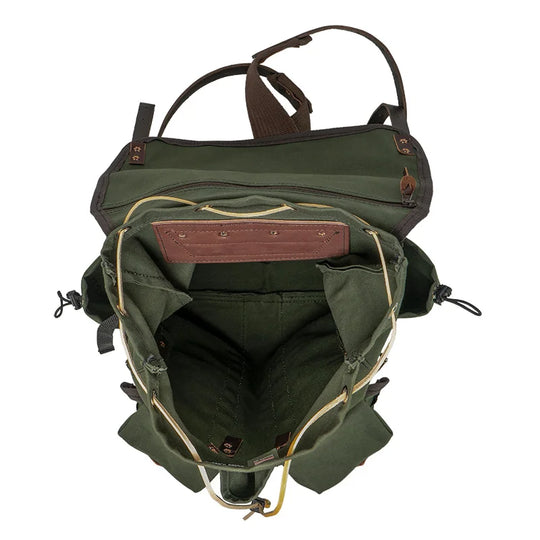 Outlander Pack in olive green canvas with leather trim, handmade for rugged outdoor use by Duluth Pack, showing spacious interior and organized compartments on a trail setting.