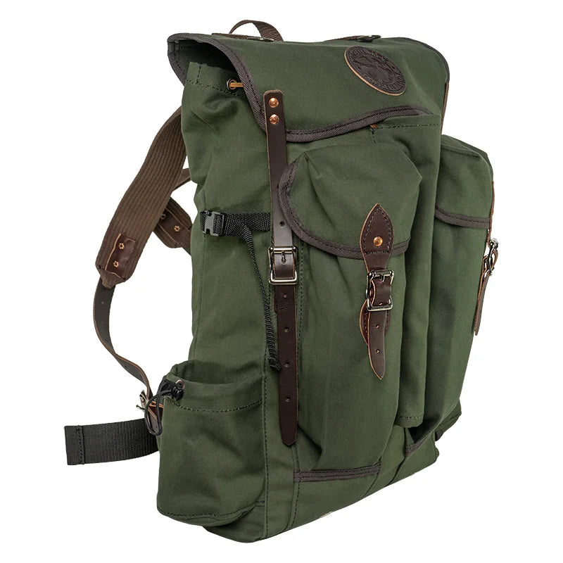 Outlander Pack in rugged green canvas with leather straps, featuring a low profile design ideal for dense wilderness trails by Duluth Pack.