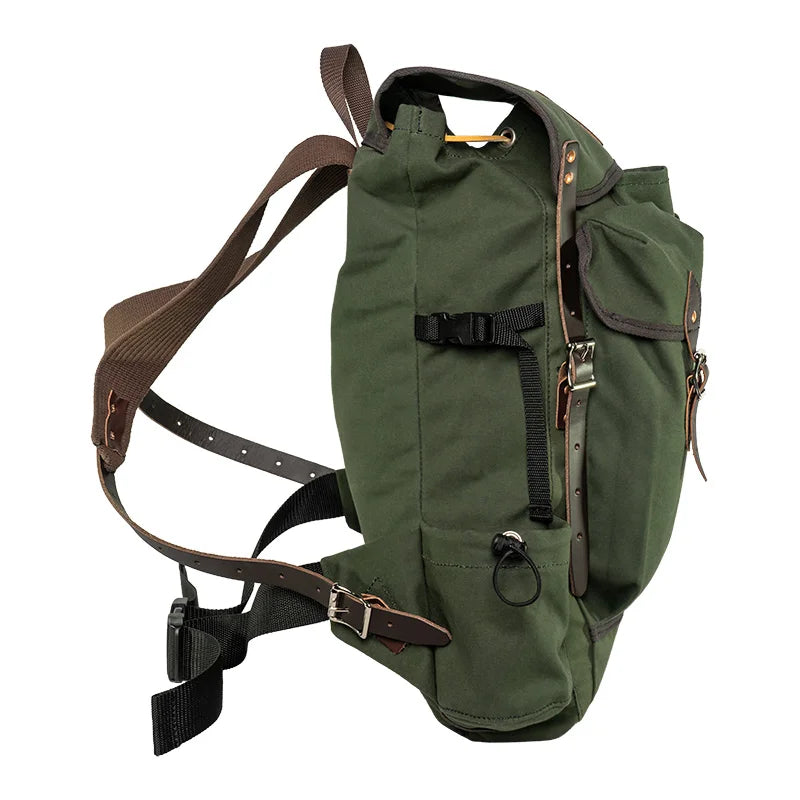 Outlander Pack in green canvas with leather straps, featuring a low-profile design and durable craftsmanship for rugged outdoor use by Duluth Pack.