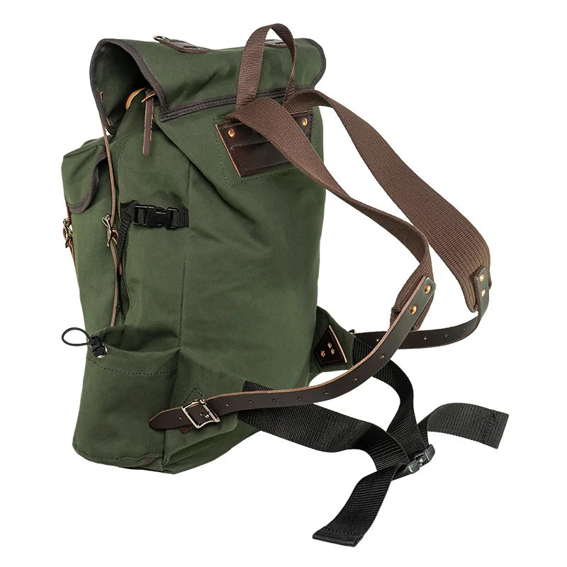 Outlander Pack in green canvas with leather accents, featuring adjustable brown straps for comfortable hiking and bushcraft in rugged outdoor settings.